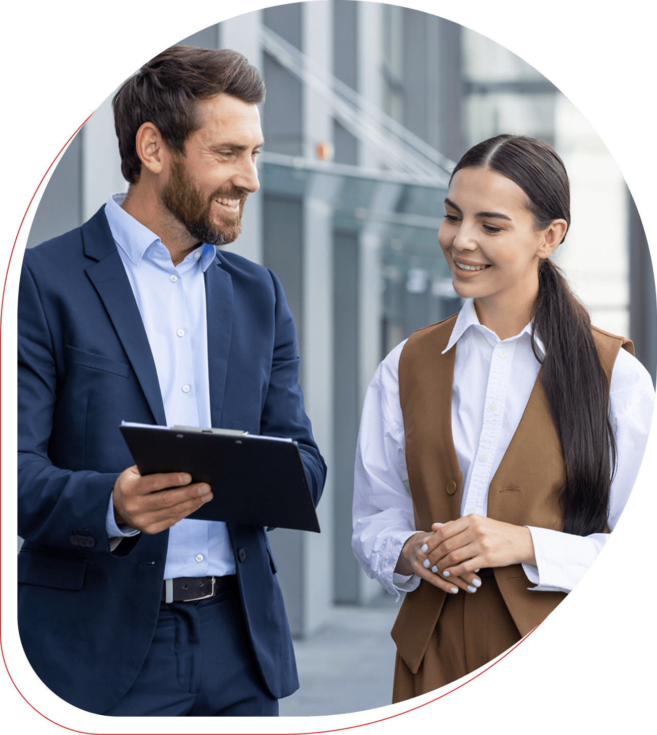 Two business professionals discussing work outdoors with a tablet.