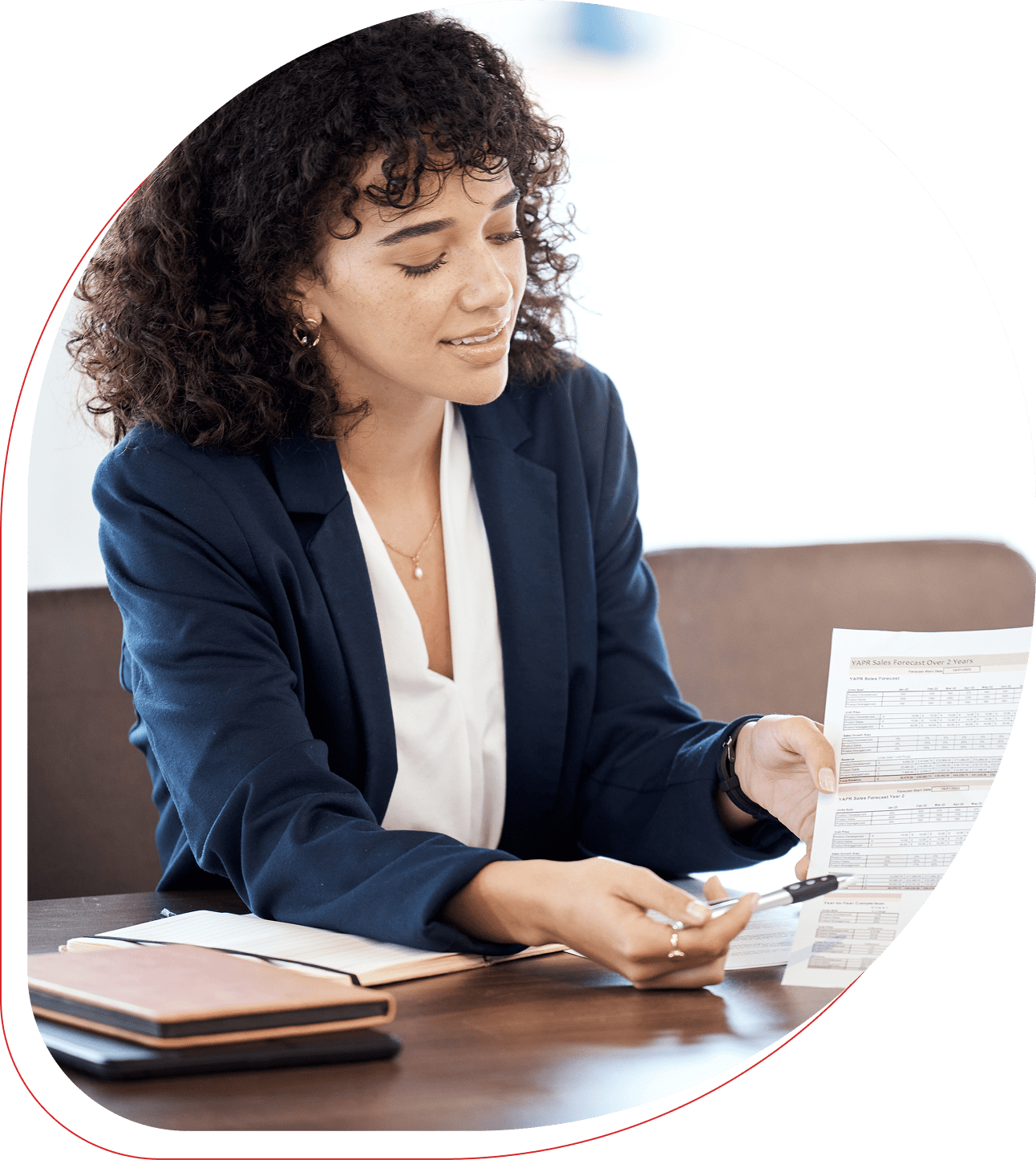 Businesswoman reviewing documents at a desk.